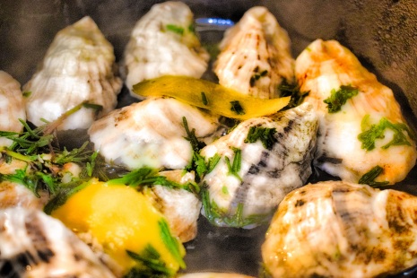 Oysters steaming in whiskey with lavender springs and lemon zest